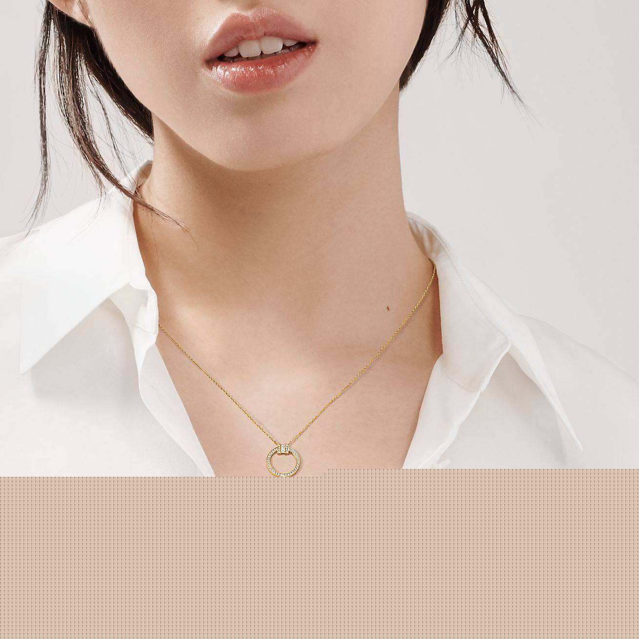 T*f*ny t diamond pendant in 18k gold with a baguette diamond